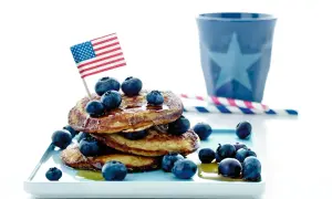 En stapel pannkakor med blåbär och en amerikansk flagga. Perfekt för att frysa pannkakor och njuta av en amerikansk frukost.