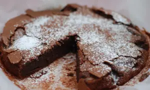 En saftig kladdkaka med pudersocker, perfekt för kladdkakans dag.