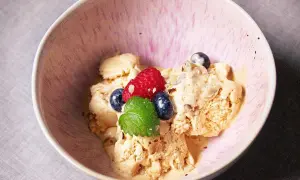En skål med krämig dulce de leche glass, toppad med färska bär och mynta. En härlig dessert som smälter i munnen.