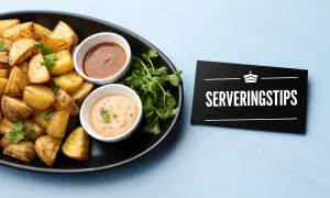 Krispiga patatas bravas med två dippsåser och en skylt med texten "Serveringstips".