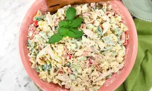 En krämig pastasallad till grillat, med farfalle, kyckling, majs, gurka och paprika. Garnerad med färsk basilika.