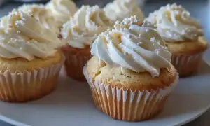 Fluffiga muffins med vit frosting, vackert spritsade rosor och strössel. En festlig syn!