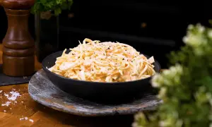 En skål med krämig, godaste coleslaw, toppad med nymalen svartpeppar. Perfekt tillbehör!