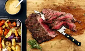 Saftig flankstek i ugn, skivad och serverad med ugnsrostade rotfrukter och en krämig sås.