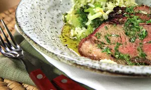 En saftig picanha, perfekt grillad, serveras med ris och grönsaker. En härlig måltid att njuta av.