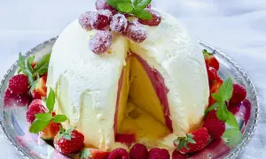 En magnifik elle nyårsdessert, en kupol av glass med lager av frukt och bär, dekorerad med färska jordgubbar och hallon.