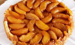 En gyllene tarte tatin med karamelliserade äppelklyftor som glänser i ljuset. En klassisk fransk dessert som doftar ljuvligt.