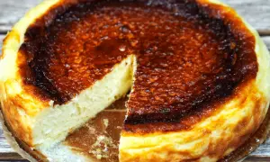 En krämig baskisk cheesecake med en härligt bränd yta, en bit är bortskuren.