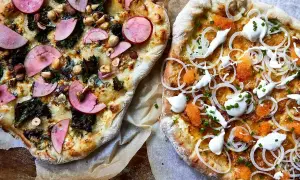 Två pizzor med egen pizza topping. En med äpple, nötter och grönkål, den andra med rom, lök och gräddfil.