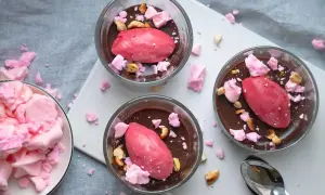 Tre glas med chokladmousse toppas med rosa sorbet, krossad maräng och nötter. Dessa goda desserter ser aptitliga ut!