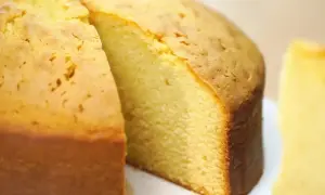 En saftig, gyllene glutenfri tårtbotten med en bit borttagen, redo att fyllas med godheter.