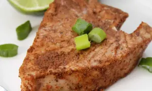 En saftig bit tonfisk, kryddad och perfekt tillagad. Serverad med lime och salladslök för en fräsch touch.