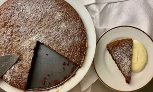 Chokladkaka med pudersocker, en bit serverad med grädde. Perfekt för att baka snabbt och enkelt.