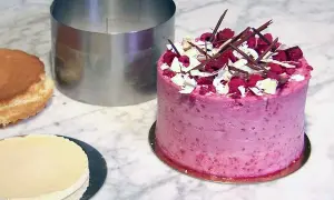 En vacker hallontårta med chokladdekorationer och grädde. Perfekt tårta inspo för nästa bakprojekt!