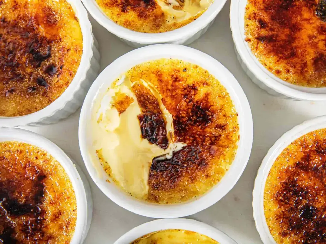 Flera crème brûlée i vita skålar, med knäckig karamelliserad yta. En riktigt god dessert!