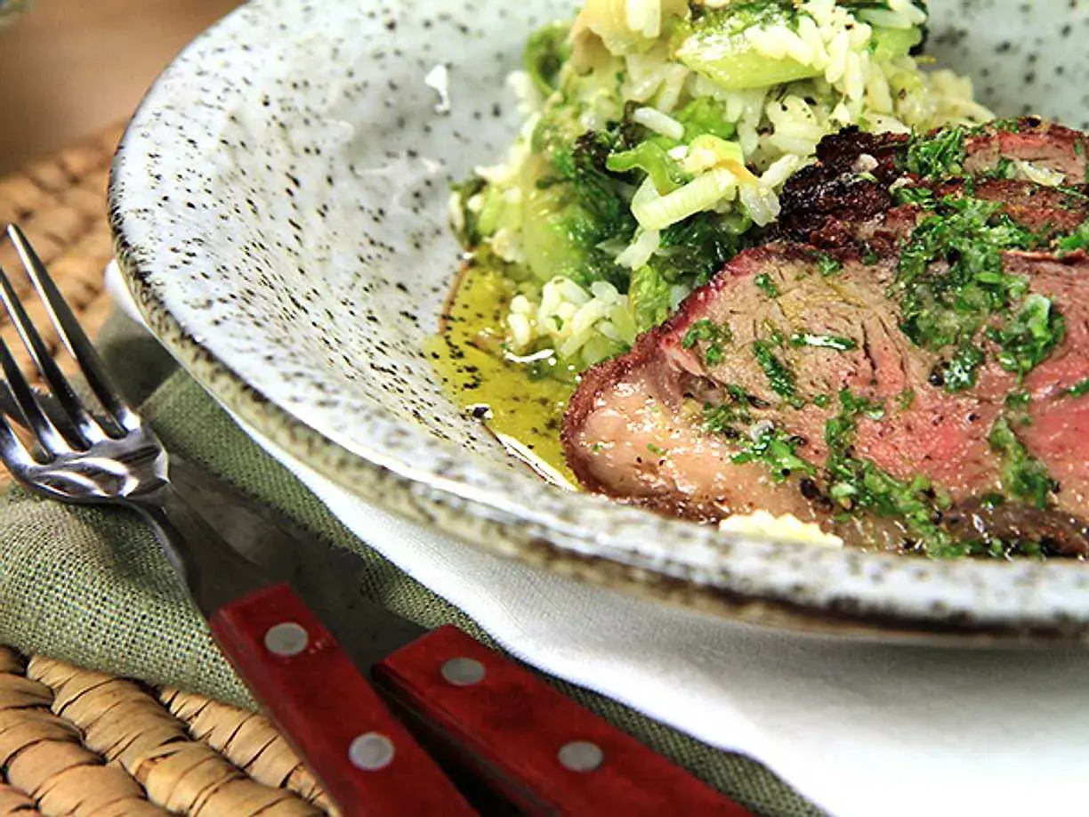 En saftig picanha, perfekt grillad, serveras med ris och grönsaker. En härlig måltid att njuta av.