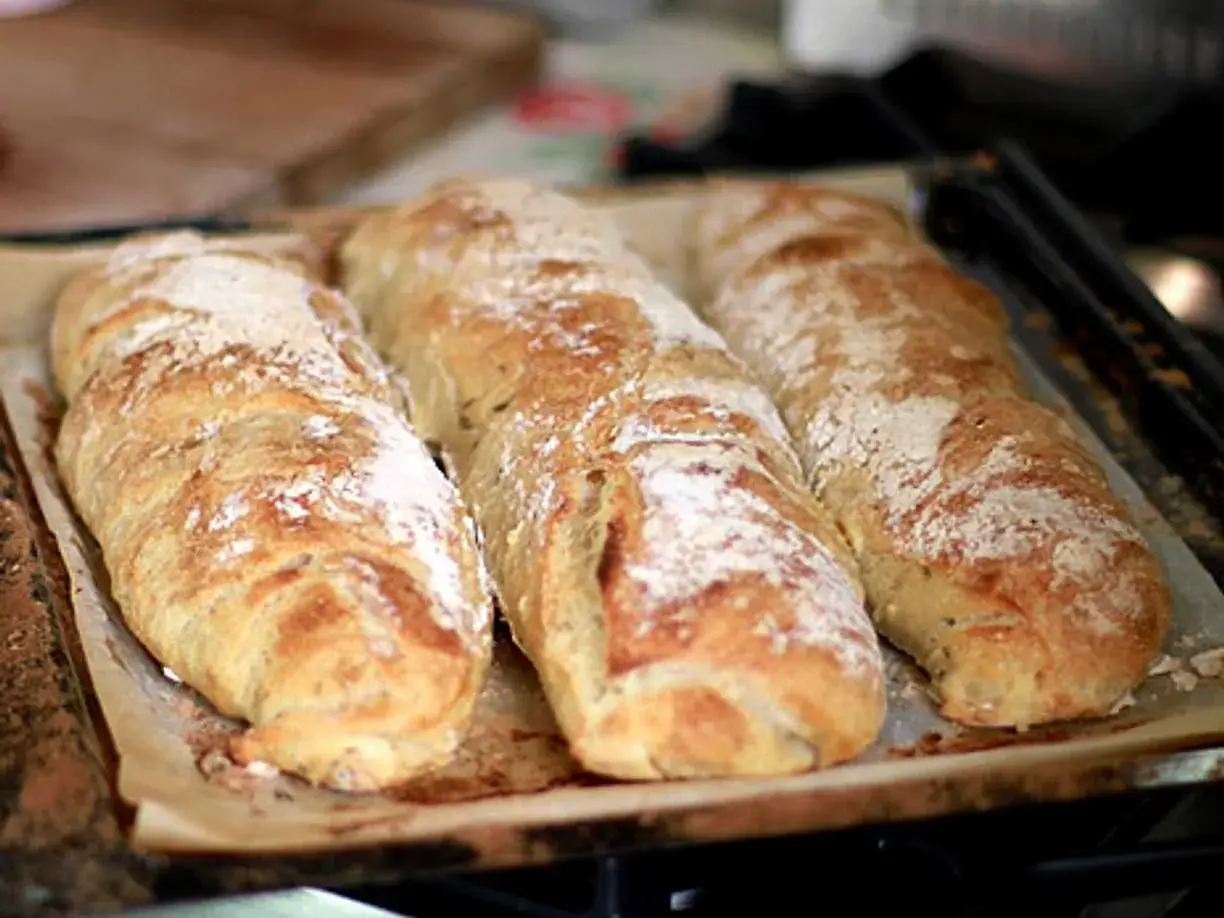 Tre nybakade surdegsbröd ligger på en plåt. Perfekt för att frysa surdeg och ha färskt bröd till hands.