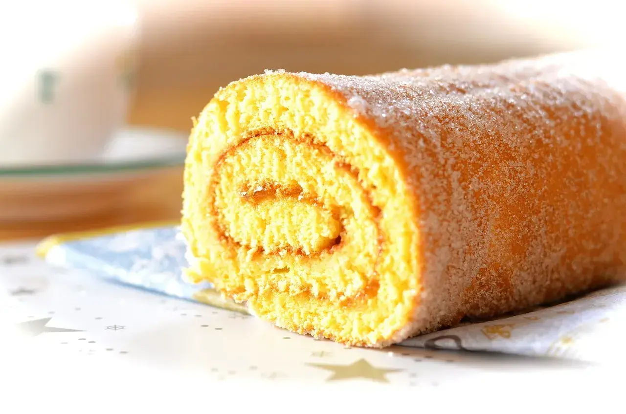 En saftig glutenfri rulltårta med sockerströssel, perfekt för fikat.