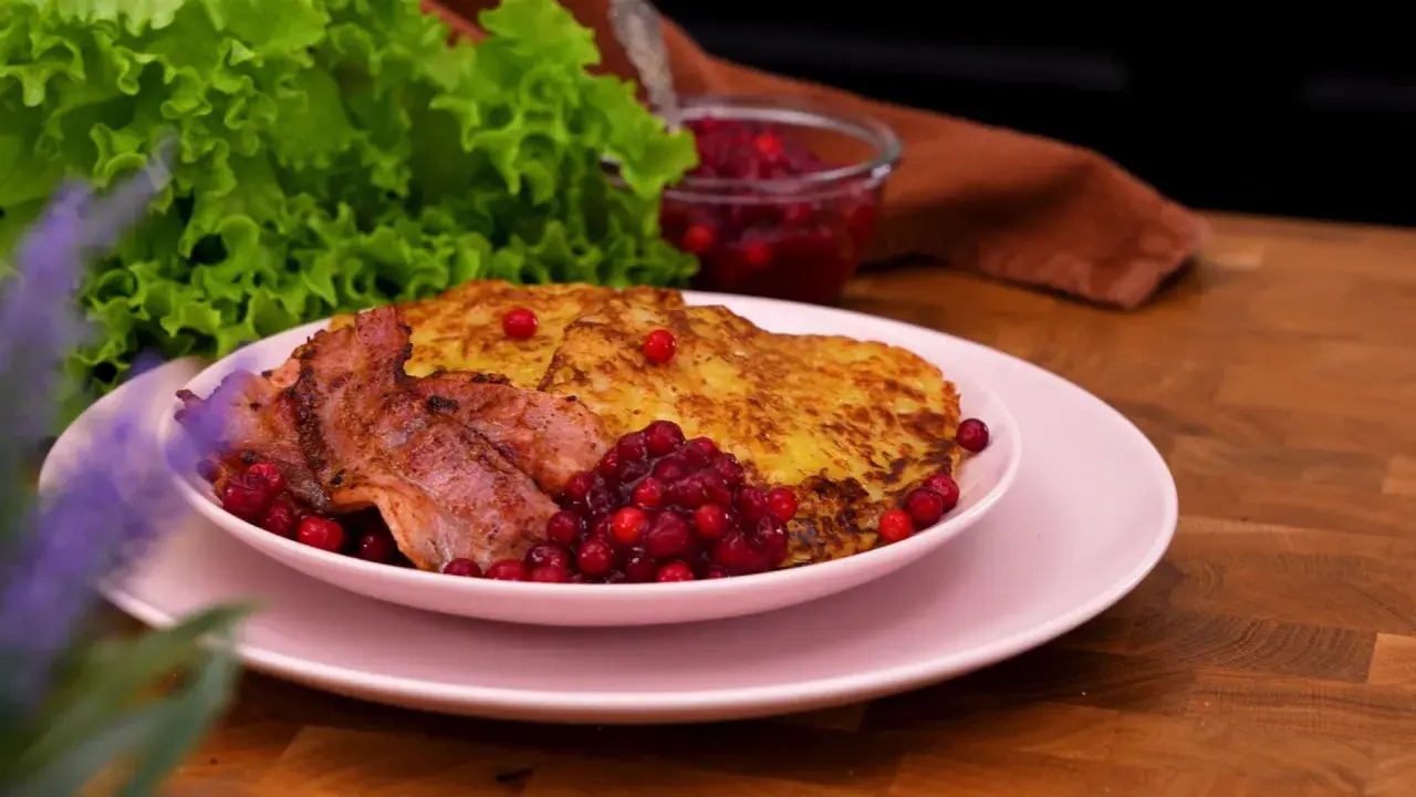 Rökt sidfläsk med stekt potatis och lingon, en härlig bit av traditionell svensk mat.