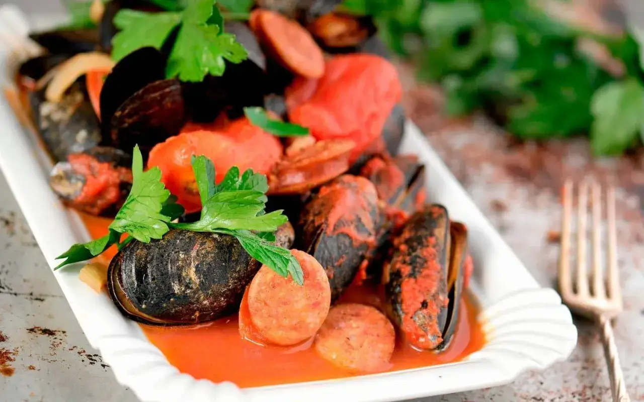 En härlig rätt med musslor och korv i tomatsås, perfekt för koka korv tid. Garnerad med persilja.