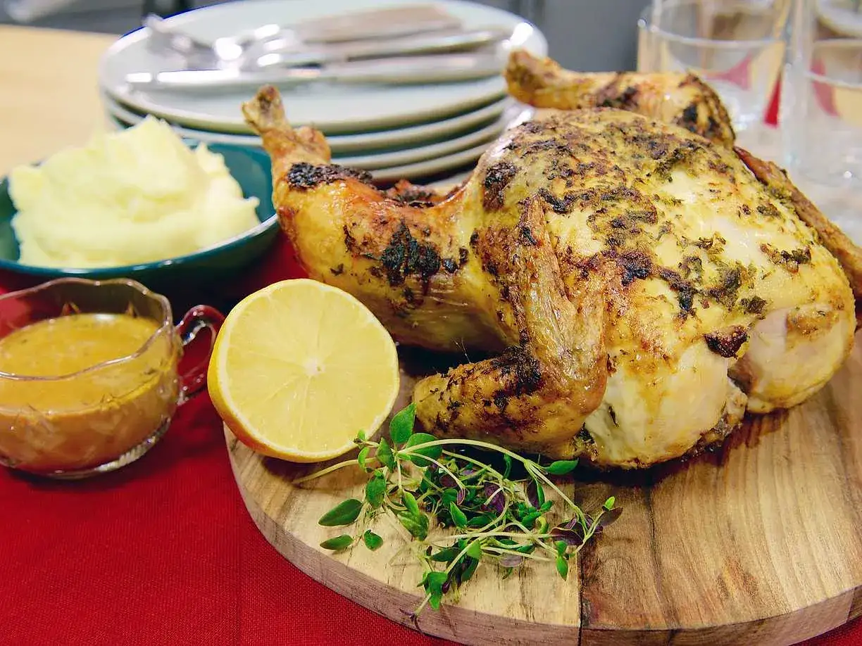 Hel kyckling med gyllene skinn, serverad med potatismos, sås och citron. Perfekt hel kyckling temperatur för en festmåltid.