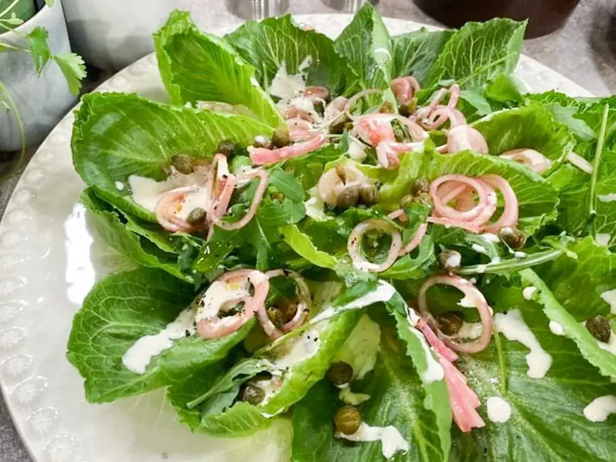 En fräsch sallad med krispig romansallat, rödlök, kapris och en krämig dressing. Perfekt som tillbehör eller som lättare sallader till mat.