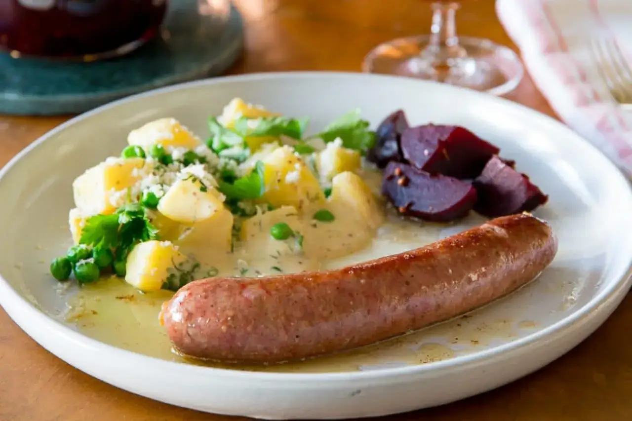 En tallrik med stuvad potatis, &auml;rtor, r&ouml;dbetor och en stekt isterband. En klassisk svensk m&aring;ltid.