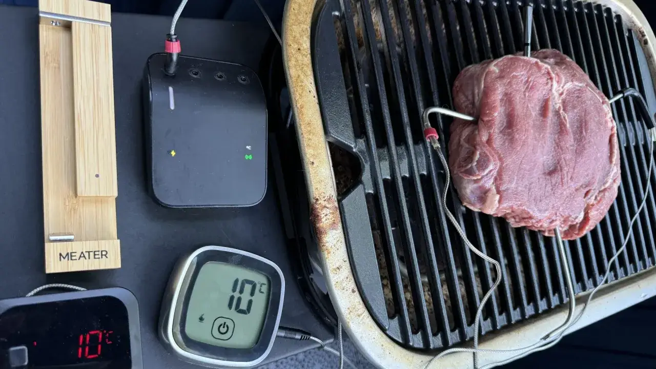 En stor köttbit på grillen med termometrar som mäter karre temp. En digital display visar 10°C.