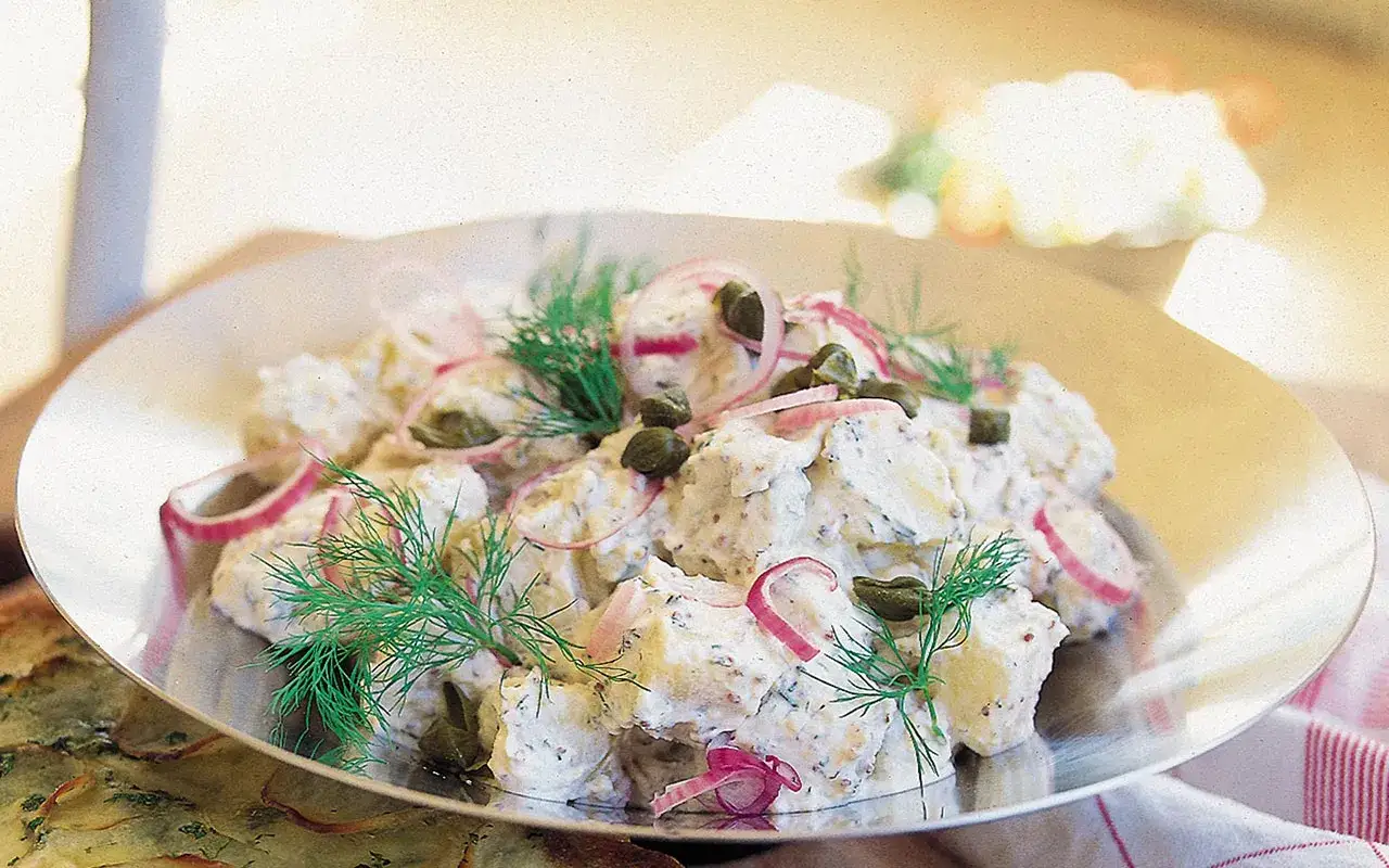 En krämig ljummen potatissallad med kapris, rödlök och dill. Perfekt till sommarens grillkvällar.