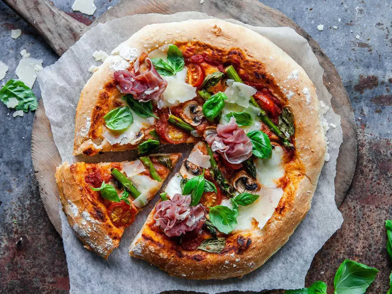 En härlig hemmagjord pizza med sparris, parmaskinka och basilika. Perfekt att baka egen pizza på!