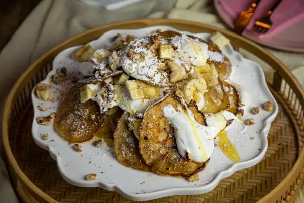 En härlig pannkakstårta med glass, banan och nötter. Pudrad med florsocker och ringlad med honung.